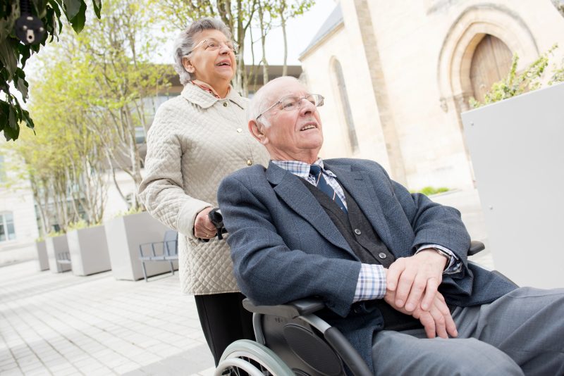 woman pushing a man in a wheelchair