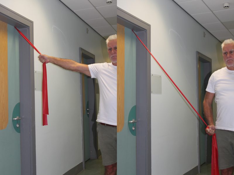 Man performing global upper limb flexion-extension exercise with a band