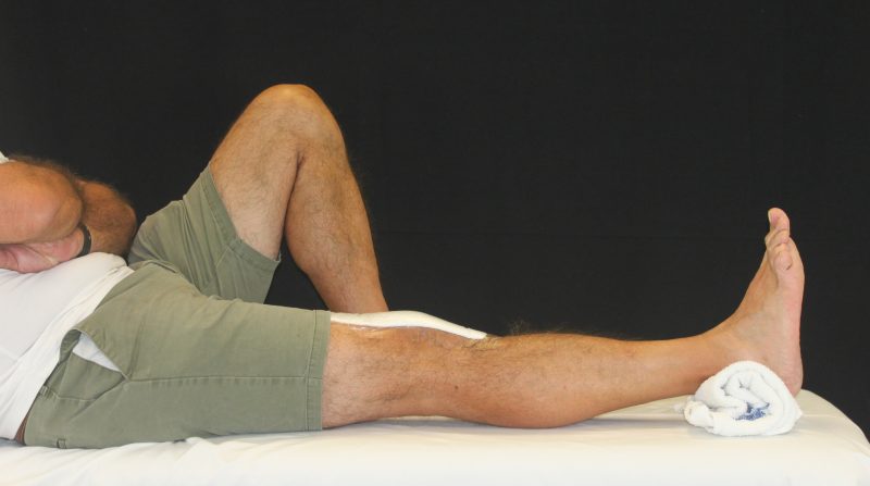 image of outstretched leg with a towel underneath the ankle