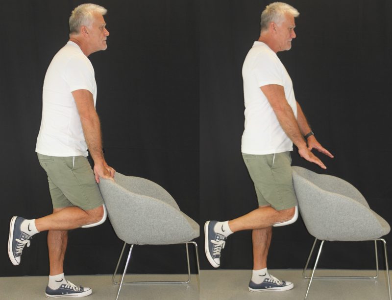 man standing in front of a chair and balancing on one leg